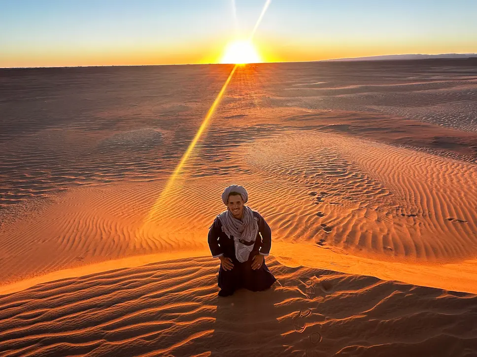 Nomade au coucher de soleil dans le désert