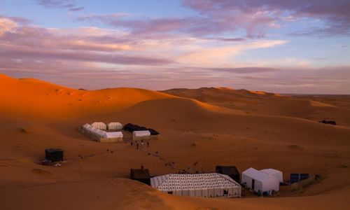 camp dans le désert à la tombée de la nuit
